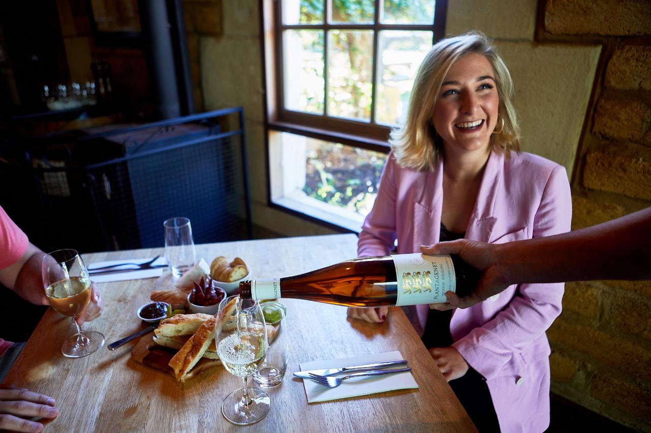 A guest smiling as Plantagenet wine is poured over a shared local-produce lunch