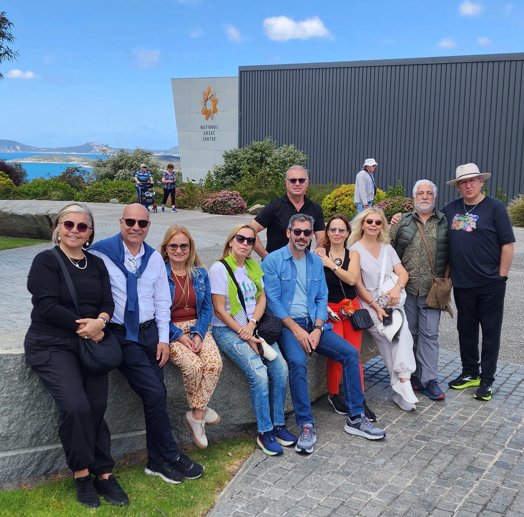 A tour group posing for a photo together outside the National Anzac Centre.